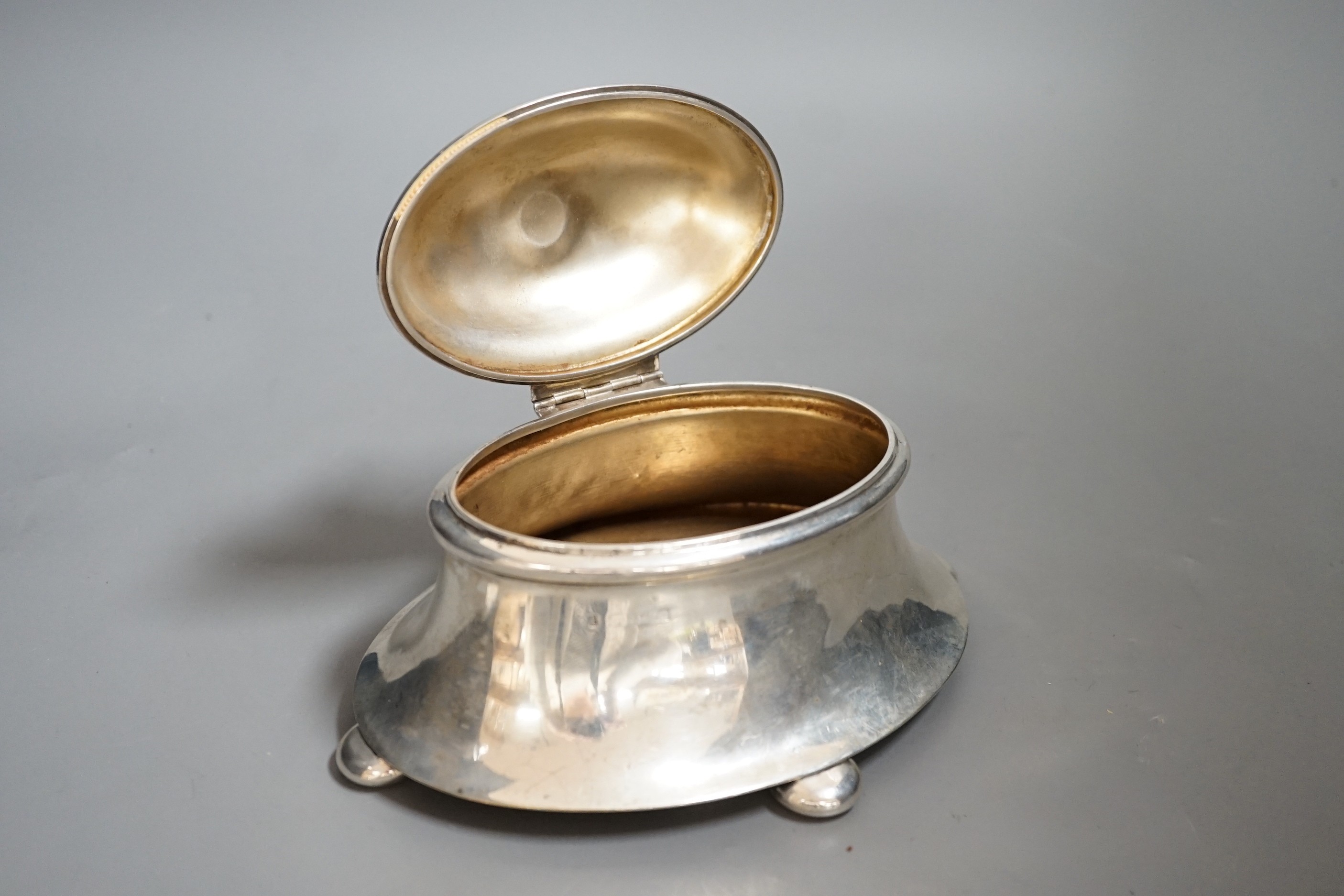 An early 20th century silver oval box, with hinged cover, on bun feet marks rubbed, length 18.5cm